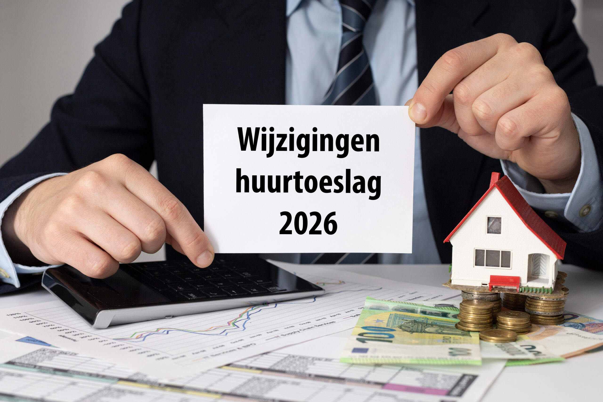 Een man die een witte kaart vasthoud met 'wijziging huurtoeslag 2026'. Naast hem ligt geld en een huis.