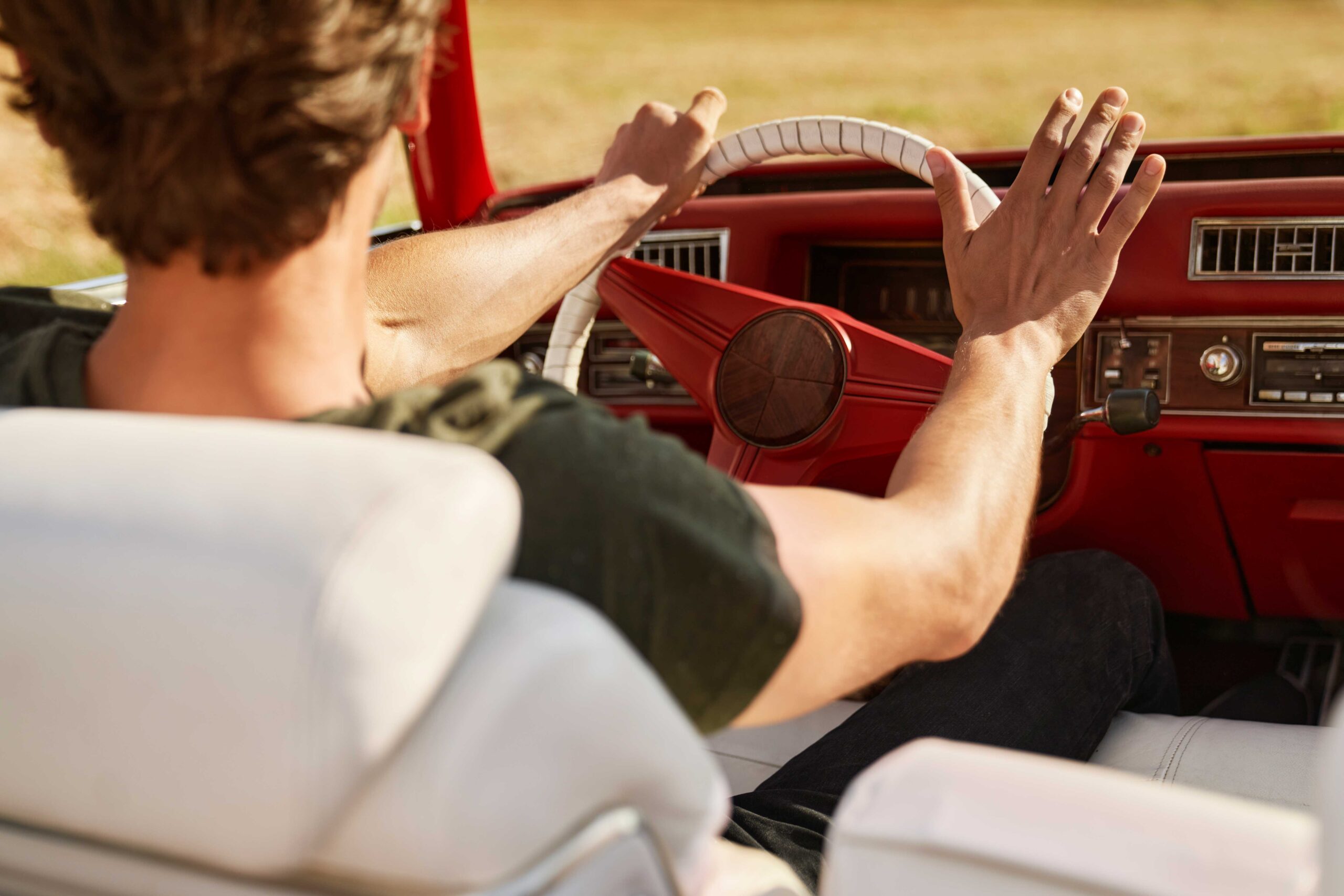 Man achter het stuur in een youngtimer
