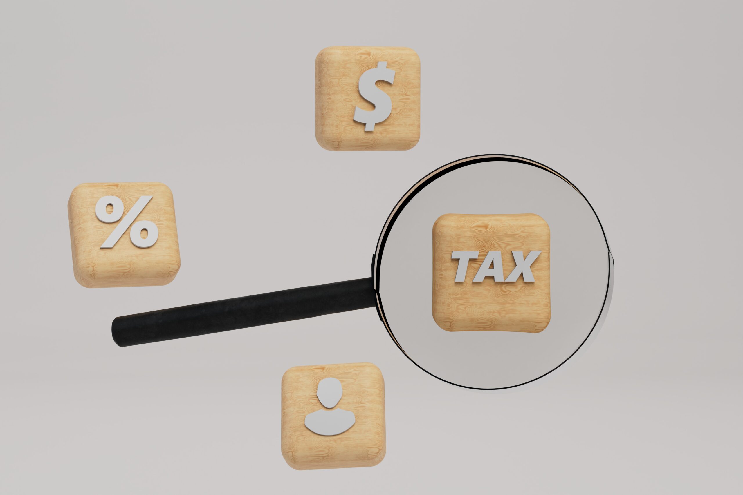 Houten blokjes met iconen waarvan het blokje met tax onder een loep ligt