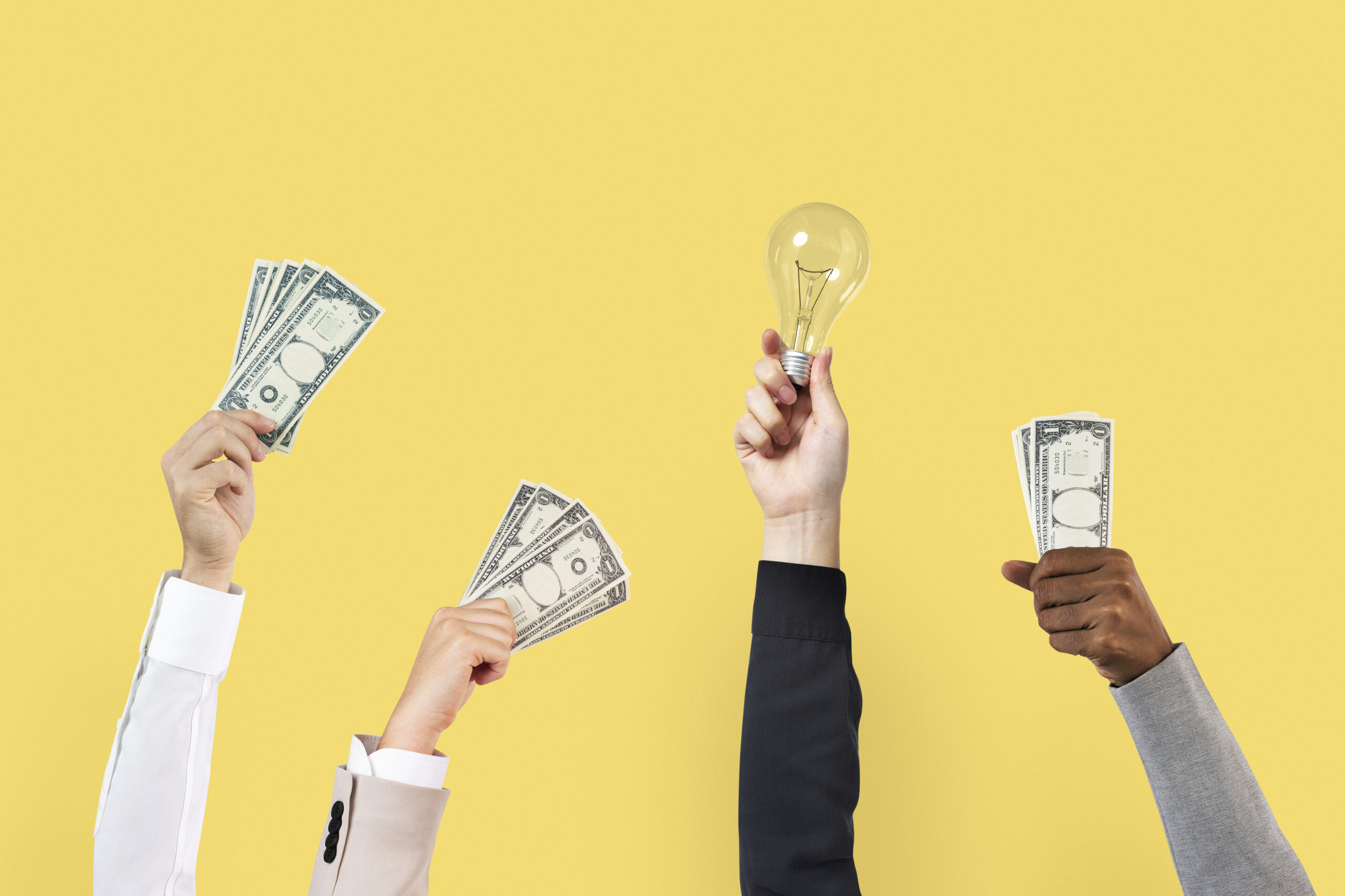 Handen die geld of een lamp vasthouden voor een gele achtergrond