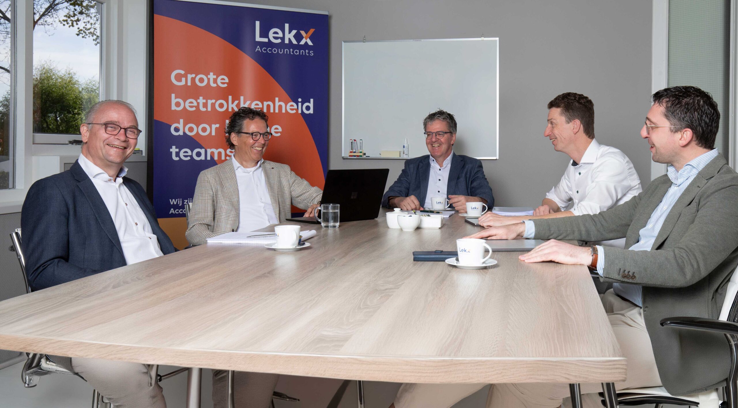 De vennoten van lekx zittend aan een vergadertafel